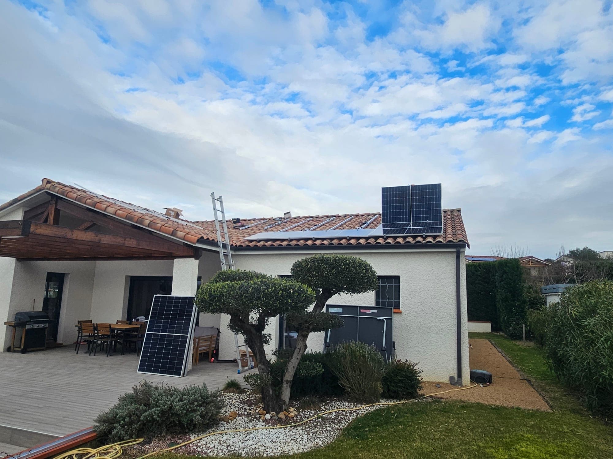 Maison en cours d'équipement photovoltaïque, échelle appuyée en façade