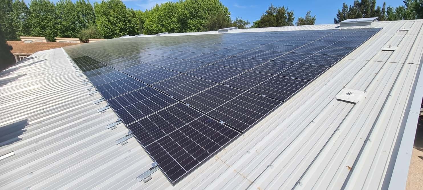 Grande toiture industrielle en bac acier recouverte de modules photovoltaïques