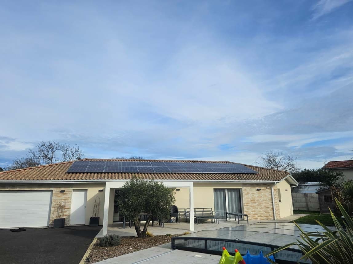 Maison équipée de panneaux photovoltaïques sous un ciel dégagé